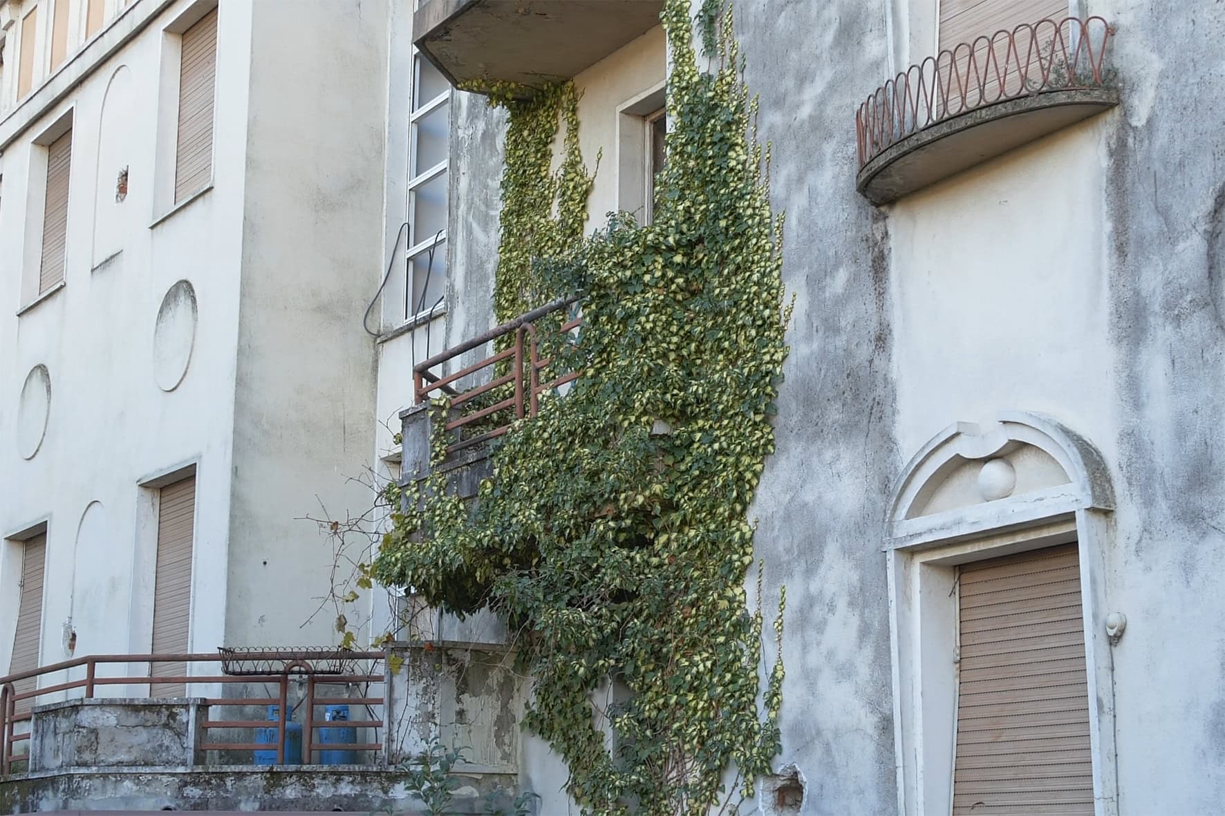 Dettaglio ravvicinato della facciata e del balcone della storica Villa Olympia a Desenzano, prima della riqualificazione in residenze di lusso