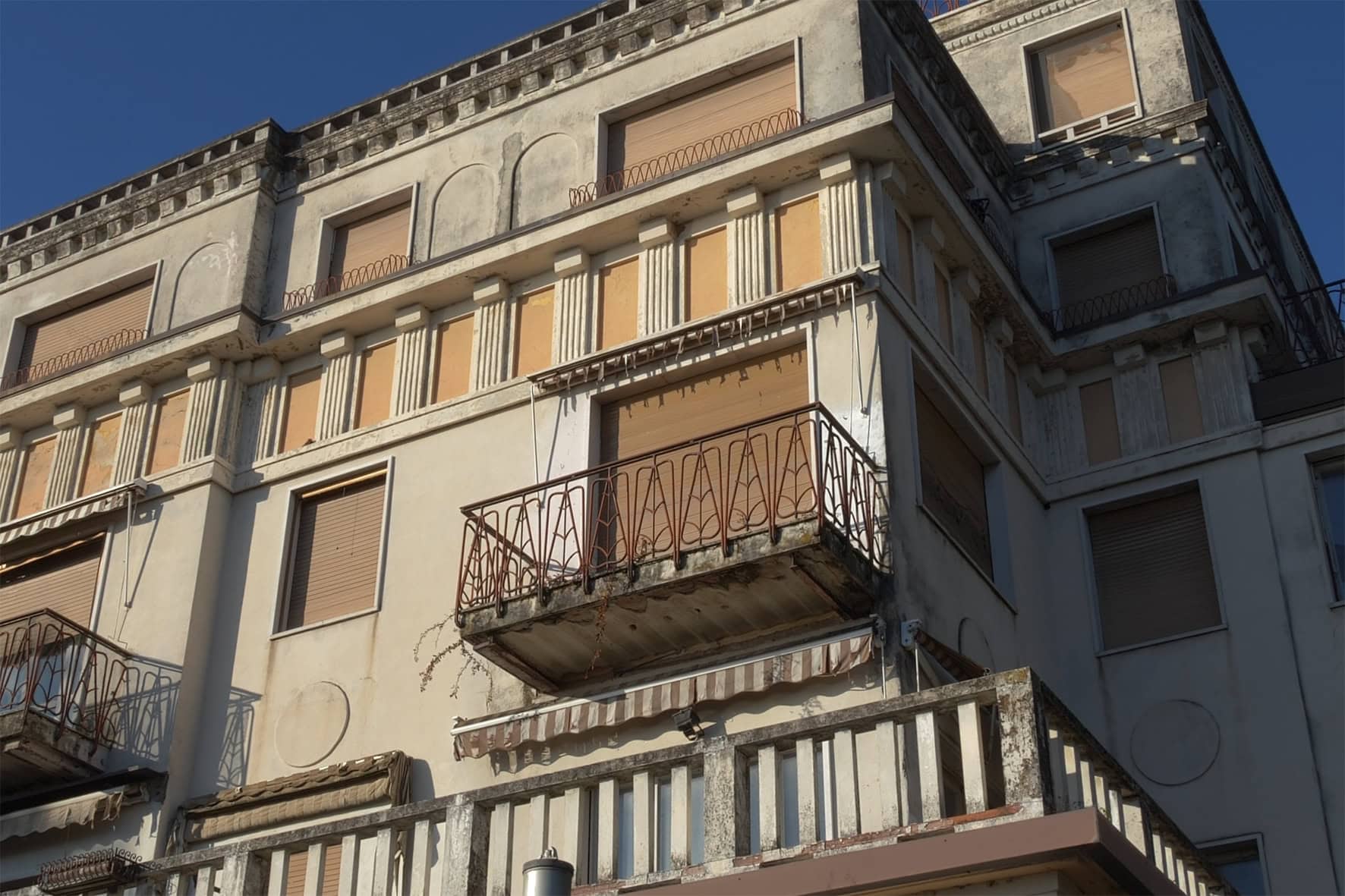 Dettaglio ravvicinato della facciata, balconi e ringhiere della storica Villa Olympia a Desenzano, prima della riqualificazione;