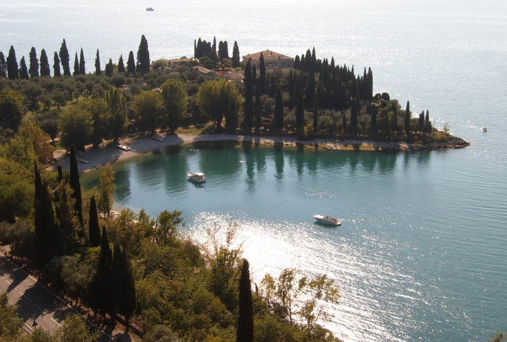 Vista aerea di Punta San Vigilio sul Lago di Garda con baia, cipressi e imbarcazioni
