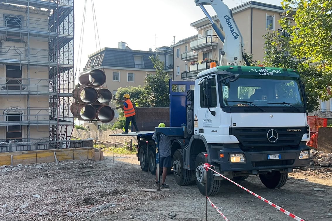 Scarico materiali e pali di fondazione nel cantiere di Villa Olympia Residences a Desenzano del Garda